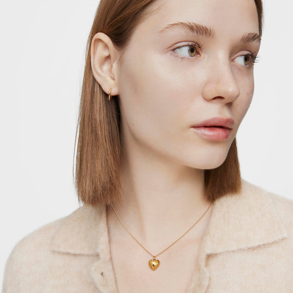 Half heart-shaped pendant in 18kt yellow gold. Pendant size 12mm